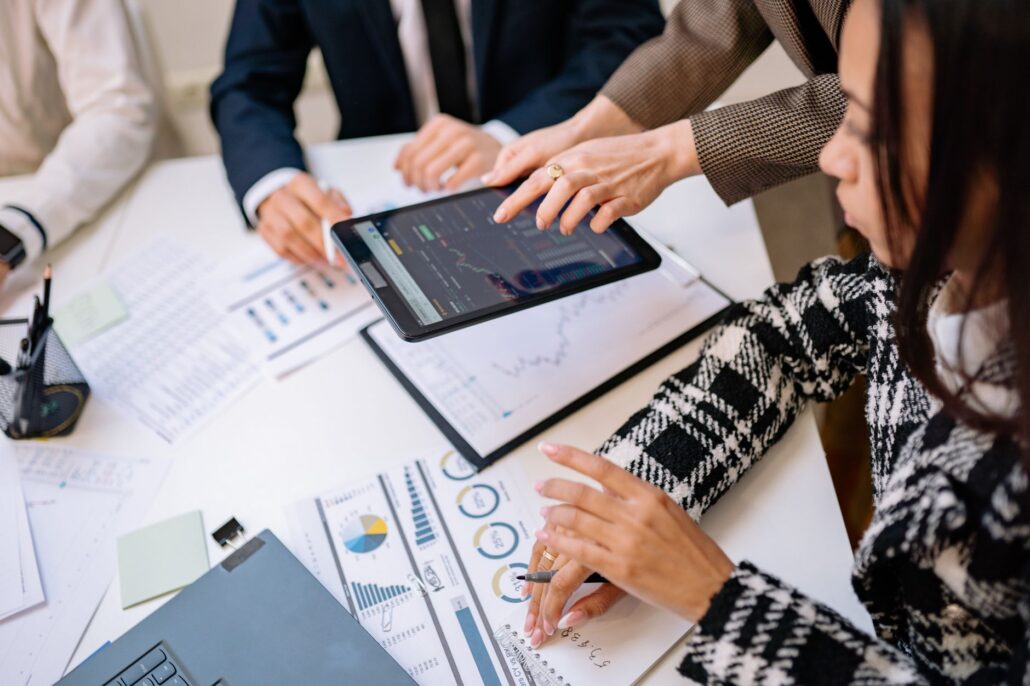 How Managed IT Services Support Long-Term Business Growth 5 Business professionals reviewing analytics on a tablet during a meeting.