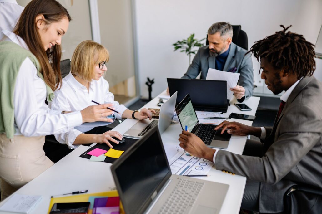 Managed IT Services For Streamlined, Scalable Business Workflows 4 A diverse team collaborates in a modern office setting with laptops and documents.